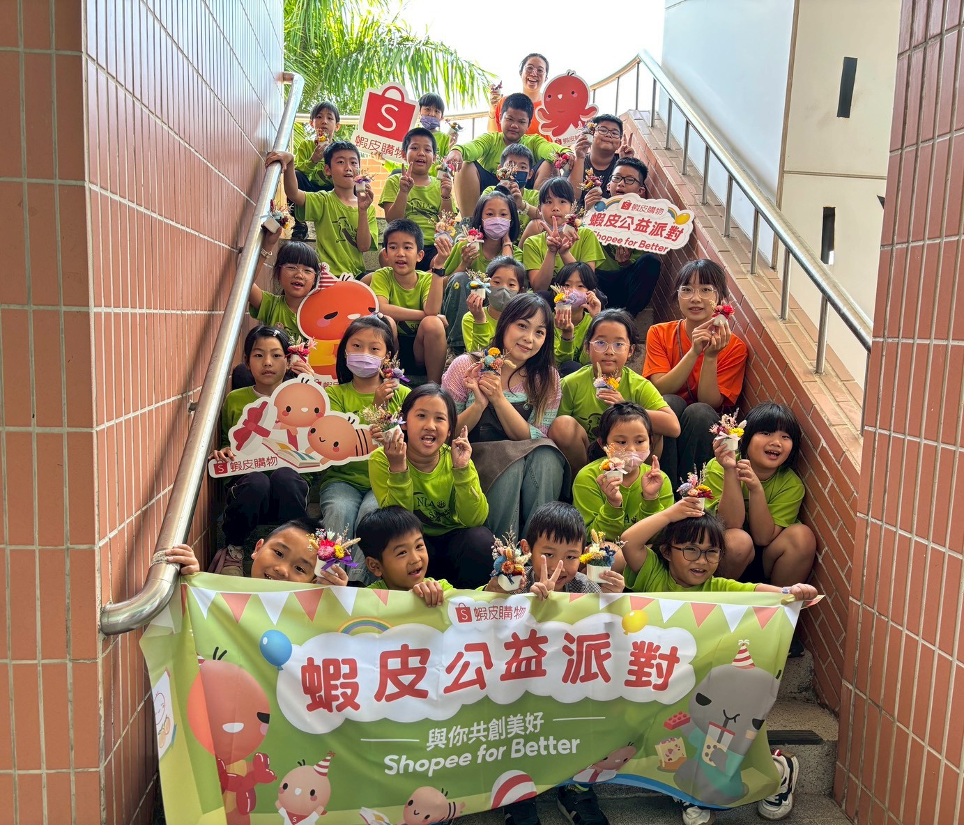 two men sitting on the grass looking at a laptop